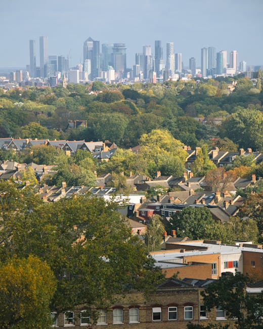 The image shows the rooftops of historic brick buildings with ornate architectural features, including conical and turreted towers, under a clear evening sky with a visible moon. The structures are part of a residential or institutional property in Sydenham Hill, featuring detailed brickwork and decorative elements along the roofline. In the foreground, a section of a modern metal roof with a polygonal shape is visible, possibly covering an extension or annex. The existing scene suggests a peaceful setting typical of London’s Southwark or Lewisham boroughs. At sunset, the warm light highlights the brickwork and architectural details, with a slight gradient in the sky from blue to soft pink near the horizon. This setting reflects the type of houses and historical buildings often associated with house removals and property moves in the Sydenham Hill area, where furniture transport and packing are part of the relocation process enabled by companies like Man with Van Sydenham Hill.